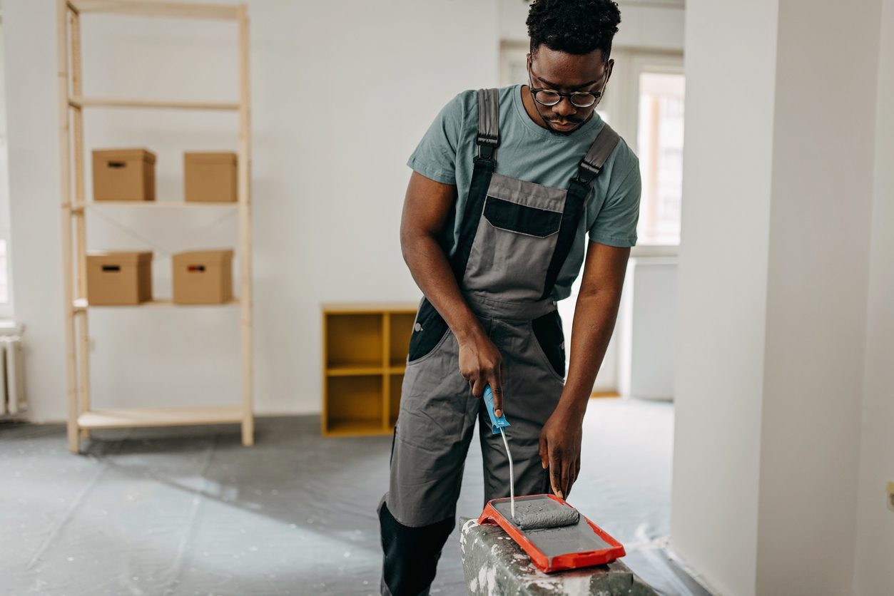 A professional painter prepares to paint the interior walls of a suburban residential home