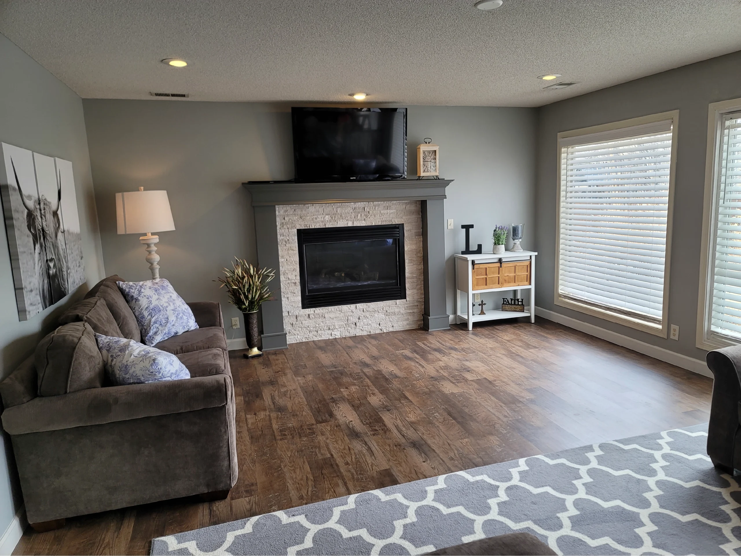 professionally painted grey living room walls and fireplace mantle with white trim and molding