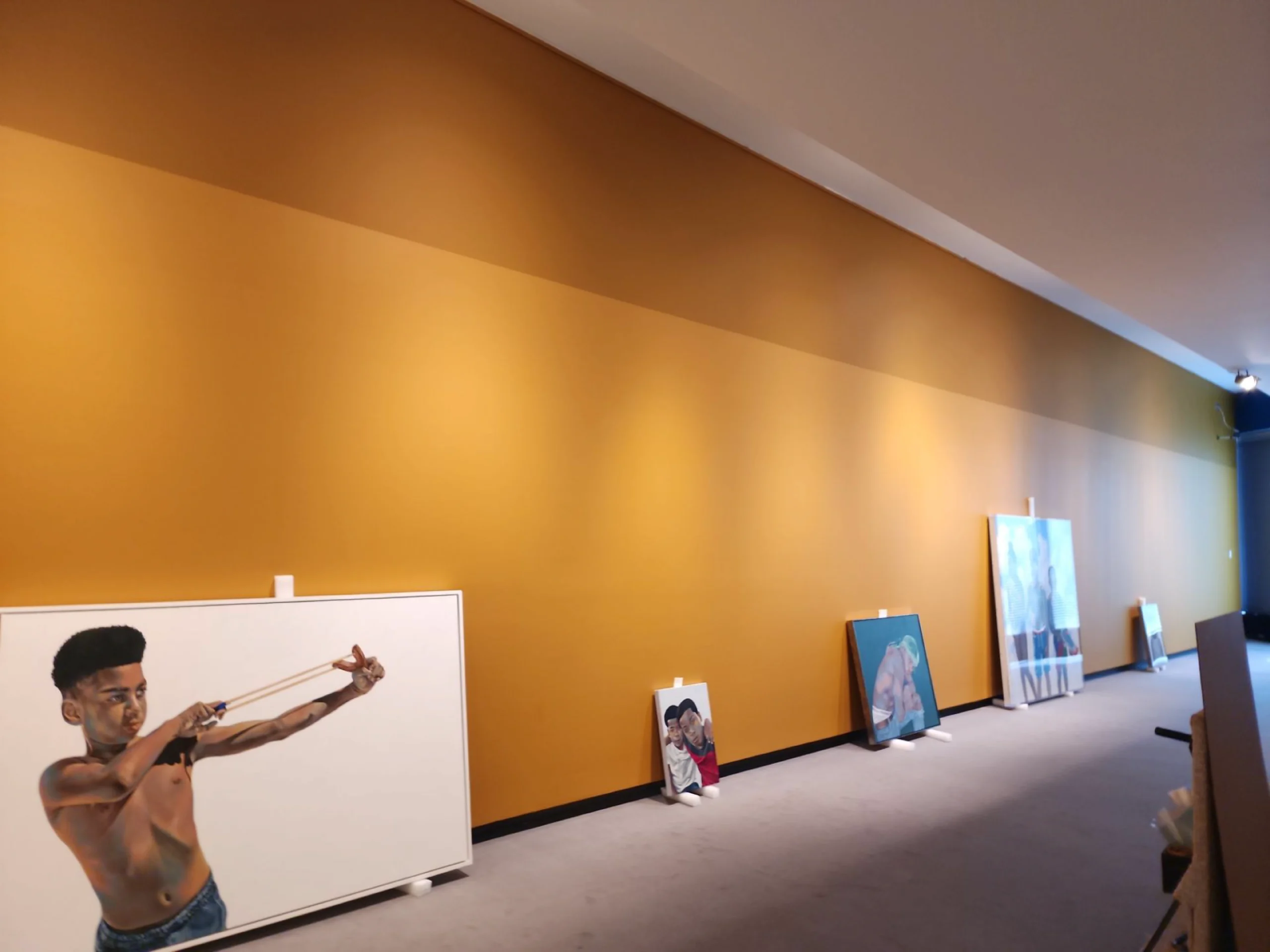 Our commercial interiors highlight a professional museum quality finish from River City Painting with a vibrant orange background wall for the installation of painter Robert Patterson's exhibit at Wichita Art Museum